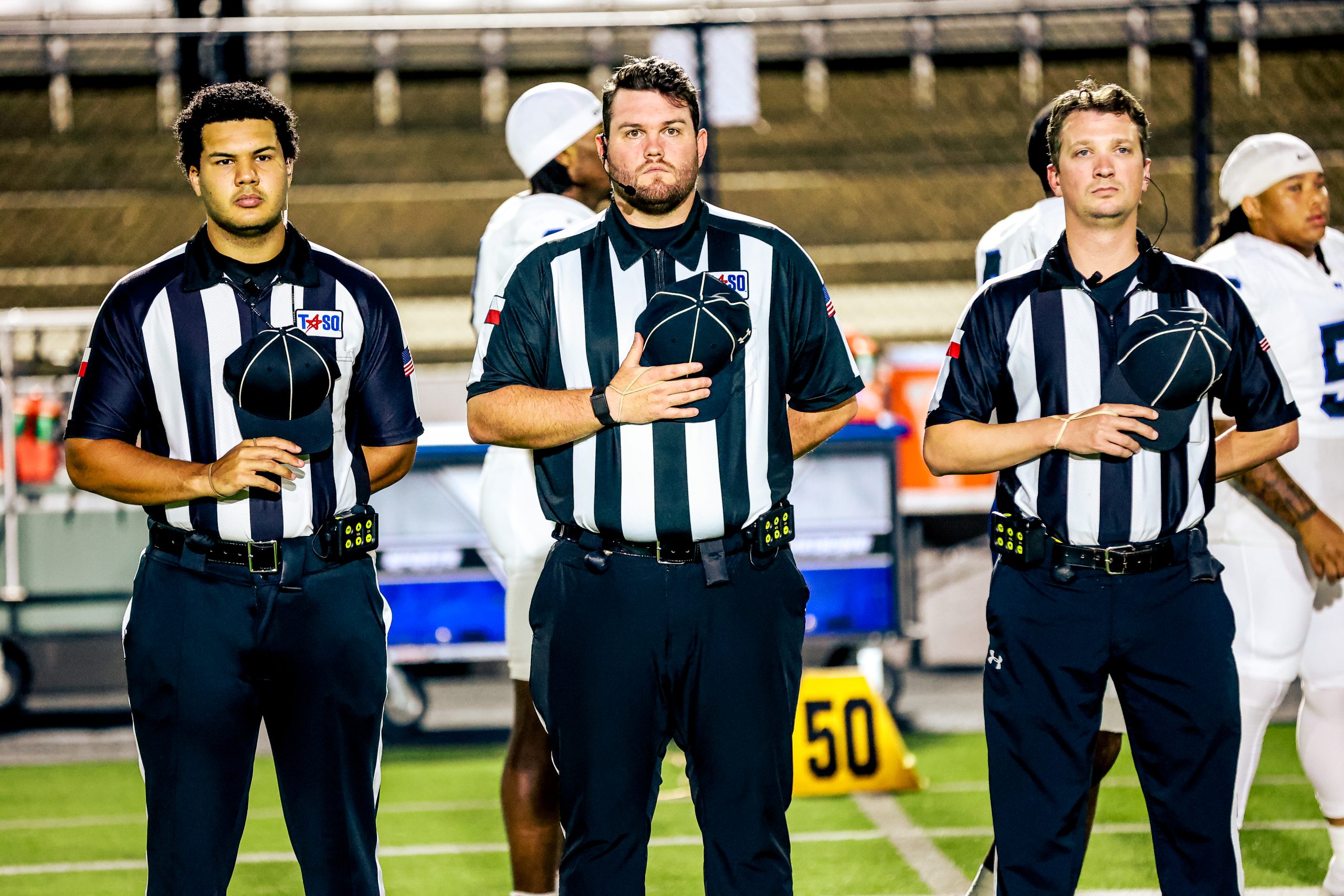 Three football officials together on the field